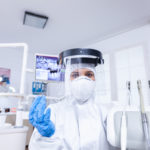 Pov of patient sitting on chair at dental office for teeth treatment Stomatolog wearing safety gear against coronavirus during heatlhcare check of patient.